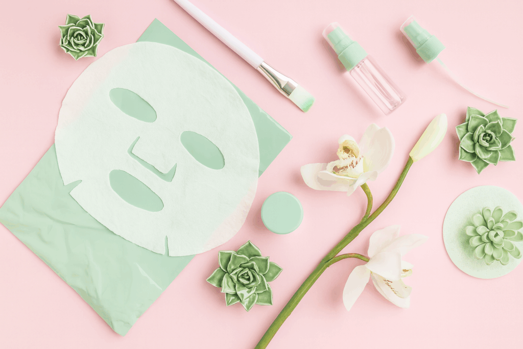 ミント色のシートマスクと美容アイテムのフラットレイ。乾燥肌のケアをイメージしたエレガントなスキンケア写真。
